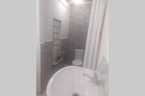 een badkamer met een wit bad en een toilet bij LANDE Tiny in Rantepao