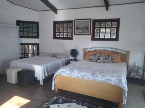una camera da letto con due letti in una stanza di Cantinho da paz 01 a Caraguatatuba