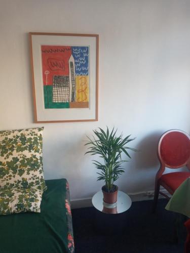 a living room with a couch and a potted plant at ETAGE voor 1-2 pers in NIJMEGEN-Centrum in Nijmegen