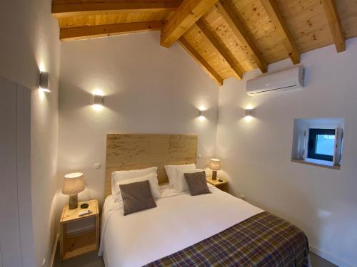 una camera da letto con un grande letto bianco con due lampade di Quinta d'Abegoa a Marvão