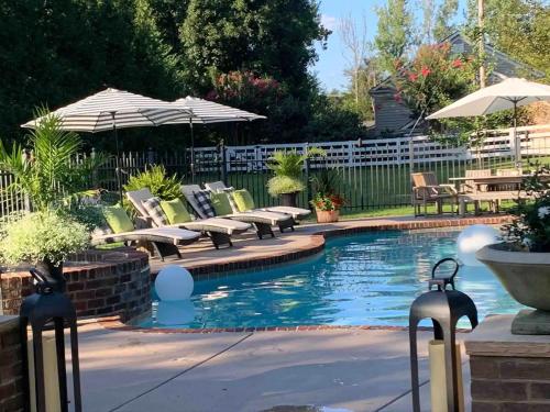 - une piscine avec des chaises longues et des parasols dans l'établissement Historic Boyd Harvey House and Grounds, à Knoxville