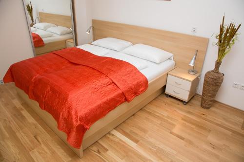 a bedroom with a large bed with a red blanket at Apartments Benedičič in Bled