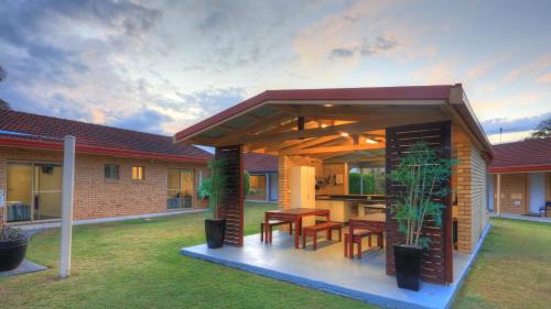 a house with a patio with a table and chairs at Yamba Motor Inn in Yamba