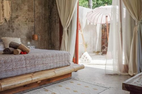 a bedroom with a bed with a canopy and a window at Kokoi Villas in Kuta Lombok
