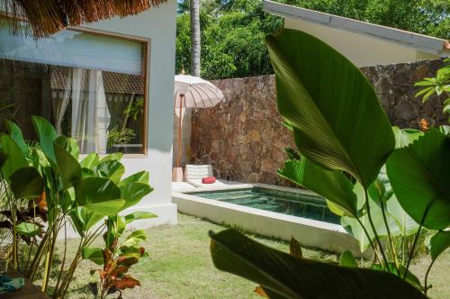 una piscina en un patio con plantas en Kokoi Villas en Kuta Lombok