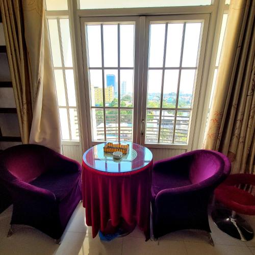 a table and two chairs in a room with a window at Hồ Tây Hotel in Thu Dau Mot