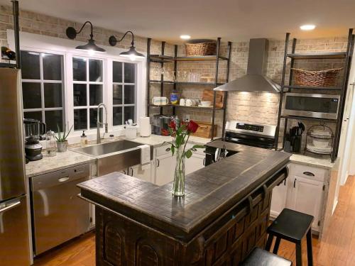 a kitchen with a counter with a vase of flowers on it at Five-Star Historic Boyd Harvey Carriage House in Knoxville