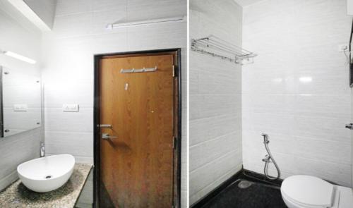 a bathroom with a toilet and a wooden door at HLVGRANDINN in Bangalore