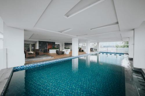 ein großer Pool mit blauem Wasser in einem Gebäude in der Unterkunft Platinum 1010 Studio Tera Apartemen Bandung City View in Bandung