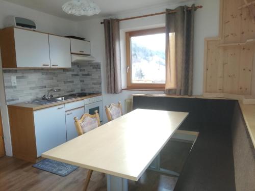 ハイミングにあるSilzerhofの白いテーブルと窓付きのキッチン