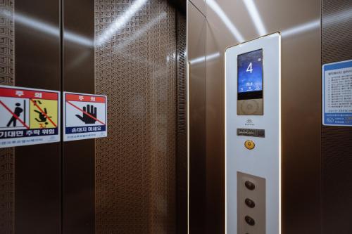 a metal elevator with signs on the side of it at The Jeongga in Jeonju