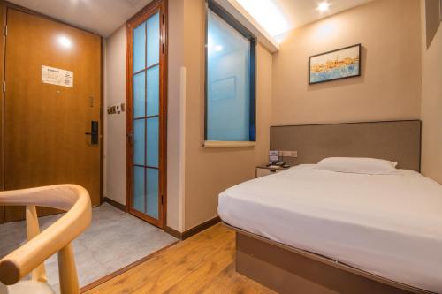 ein Schlafzimmer mit einem großen Bett und einem Fenster in der Unterkunft Hangzhou Yuqi Hotel in Hangzhou