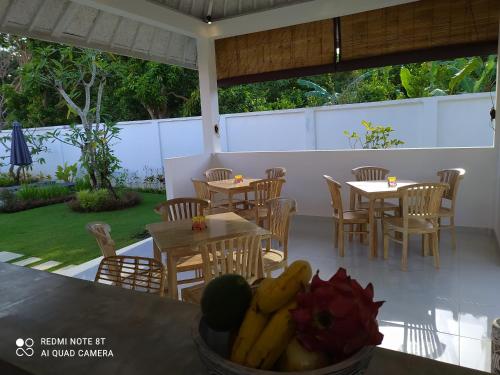 een restaurant met tafels en stoelen en een kom bananen bij Villa Bukit Sweet Home in Uluwatu