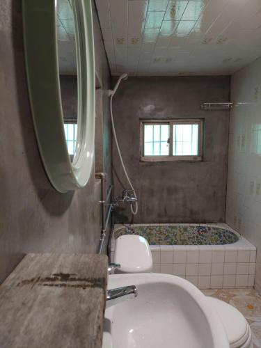 Un baño con bañera, inodoro y lavabo. en Odyssey Divers Hostel, en Xiaoliuqiu