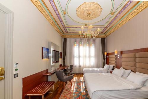 a hotel room with two beds and a chandelier at Blue Gilroy Hotel in Istanbul