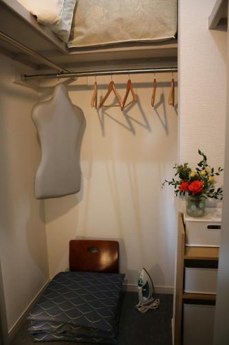 a room with a bed and a shelf with hangers at Chiyoda-Home　Osu-sakae-Subways-JR trin-Spa-parking spot-WIFI in Nagoya