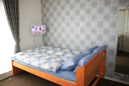 a bed in a room with a tv on a wall at Chiyoda-Home　Osu-sakae-Subways-JR trin-Spa-parking spot-WIFI in Nagoya