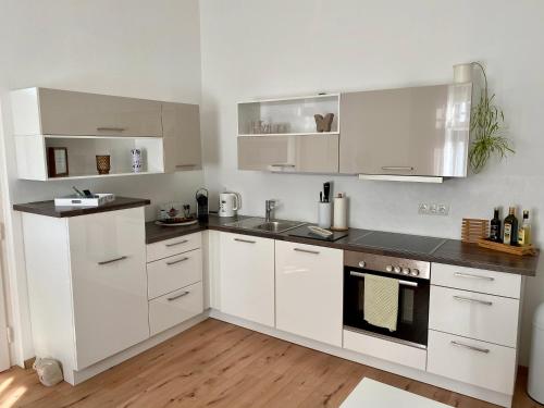 uma cozinha com armários brancos e bancadas pretas em Apartment im Grünen em Leoben