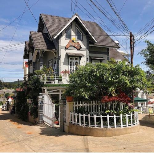 a house with a white fence in front of it at Lính Homestay Đà Lạt in Da Lat
