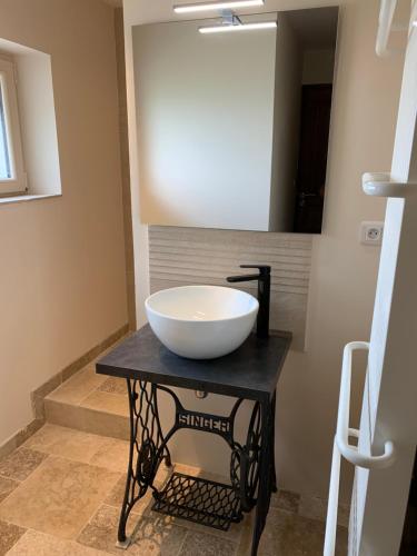 a bathroom with a bowl sink on a table at Chambre d'hotes la Quercynoise in Montaigu-de-Quercy