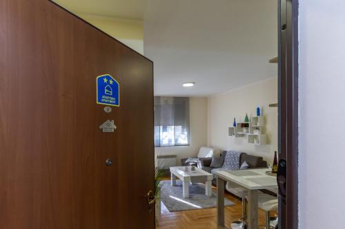 uma porta que leva a uma sala de estar com uma mesa em Predo Apart em Zlatibor