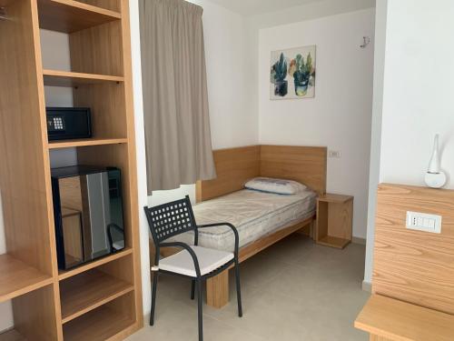Habitación pequeña con cama y silla en Miriasol Bed and Breakfast, en Capo Vaticano
