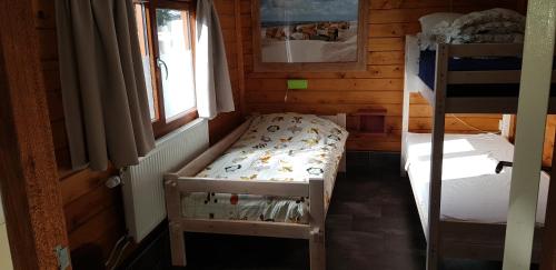 a small room with two bunk beds in a cabin at Vrijstaande blokhut in Egmond-Binnen