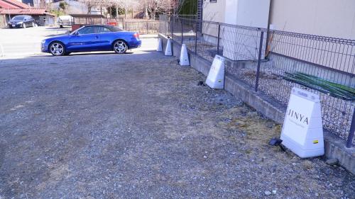 a blue car parked in a parking lot next to a fence at JINYA Fujikawaguchiko in Fujikawaguchiko