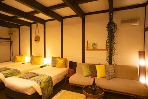 a room with two beds and a couch at JINYA Fujikawaguchiko in Fujikawaguchiko