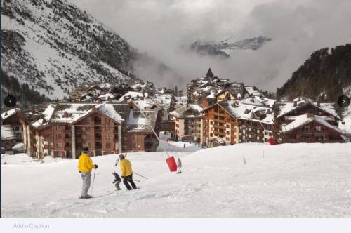 a group of people skiing in the snow in front of a lodge at Arc 1950 Ski in Ski out and Spa- Newly refurbished 153 Sources De Marie- 2 bedroom , 2 bathroom-Sleeps 4-6, Mont Blanc view from every window, Free WiFi in Arc 1950