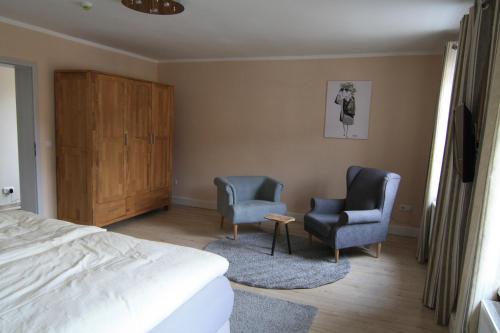een slaapkamer met 2 stoelen en een bed bij harz-traum.2 in Gernrode - Harz