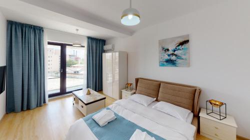 a bedroom with a bed and a large window at Le Blanc ApartHotel in Bucharest