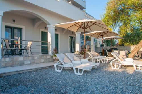 a group of chairs and umbrellas on a patio at Beach Apartments in Tivat