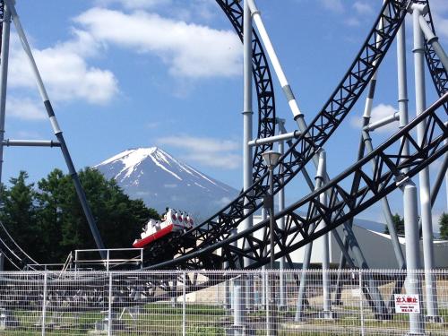 a roller coaster with a snow covered mountain in the background at JINYA Fujikawaguchiko in Fujikawaguchiko