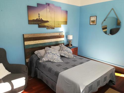 a blue bedroom with a bed and a chair at Casa Guillan Illa de Arousa in Isla de Arosa