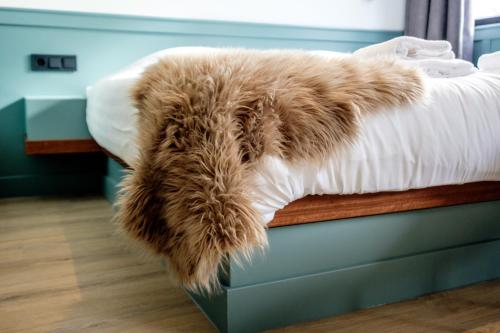 a brown furry blanket laying on a bed at Hotel Brasserie Smits in Wemeldinge