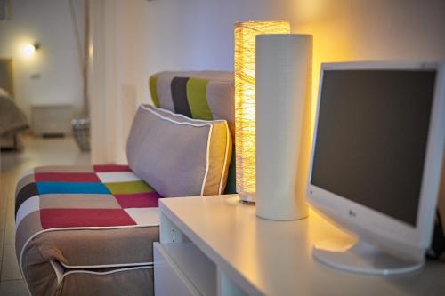 a desk with a computer monitor and a couch at La Pervinca Apartments in Malcesine