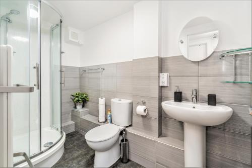 y baño con aseo, lavabo y ducha. en Central Apartment With 55” Smart TV+Netflix en Andover