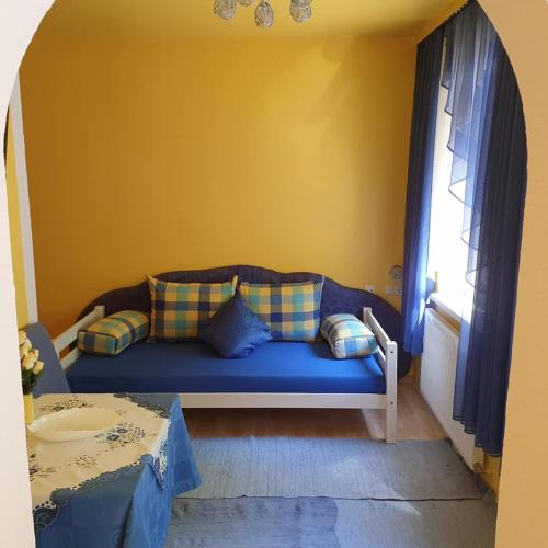 a blue couch in a room with a window at Haus Alpenrose in Seeboden