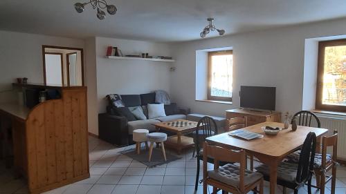 un salon avec une table et un canapé dans l'établissement Briançon-Serre Chevalier - Apt 3 pièces - 4 à 6 couchages - Au calme-Jardin mis à dispo, à Briançon