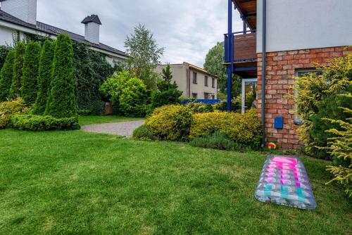 a mattress laying on the grass in a yard at Villa Baltic Apartament nr 3 in Chałupy
