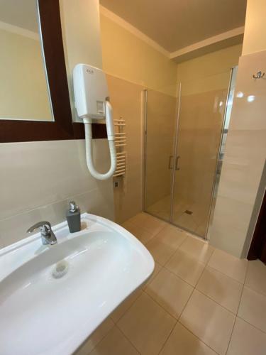 a bathroom with a white sink and a shower at Villa Baltic Apartament nr 3 in Chałupy