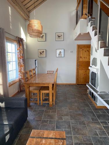 a living room with a wooden table and a staircase at Levi Kaakkuri 6 in Levi