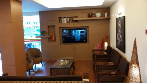 a living room with a tv and a table and chairs at Smart Hotel in Seremban