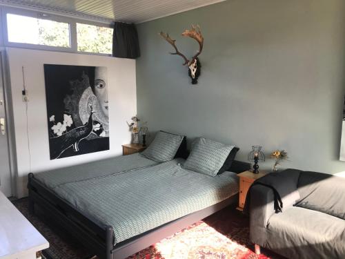 a bedroom with a bed and a couch and a window at De Vlies in Venray