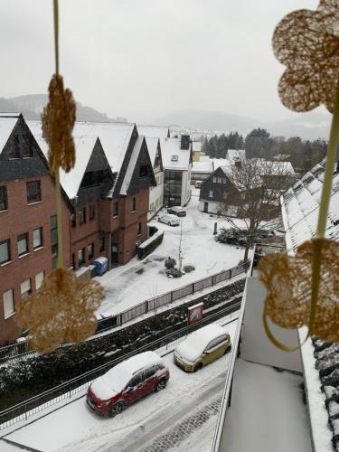 a snow covered city with cars parked on a street at Hotel Wittgensteiner Hof in Bad Laasphe