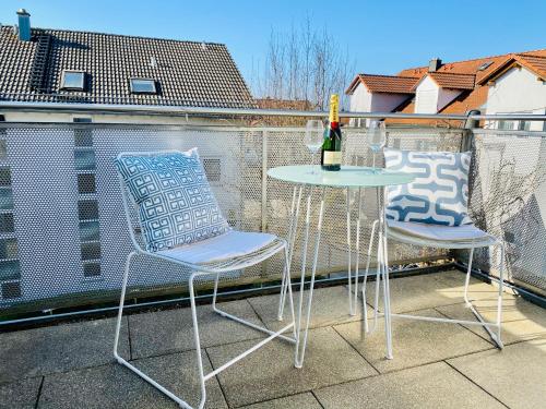two chairs and a table on a balcony at Ferien-Apartment Seewiesen - mit priv Strandzugang in Friedrichshafen