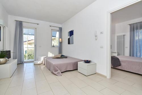 a bedroom with two beds and a television in it at La Pervinca Apartments in Malcesine