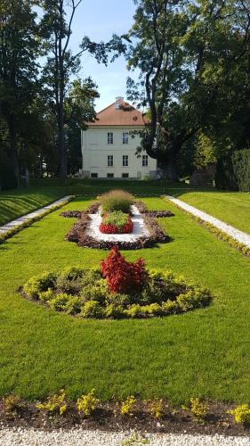 a house with a garden in the middle of a field at Pałac Nakomiady in Nakomiady