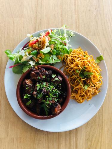 a plate of food with noodles and salad on a table at Hotel restaurant LA PLACE in Saint-Amand-Montrond